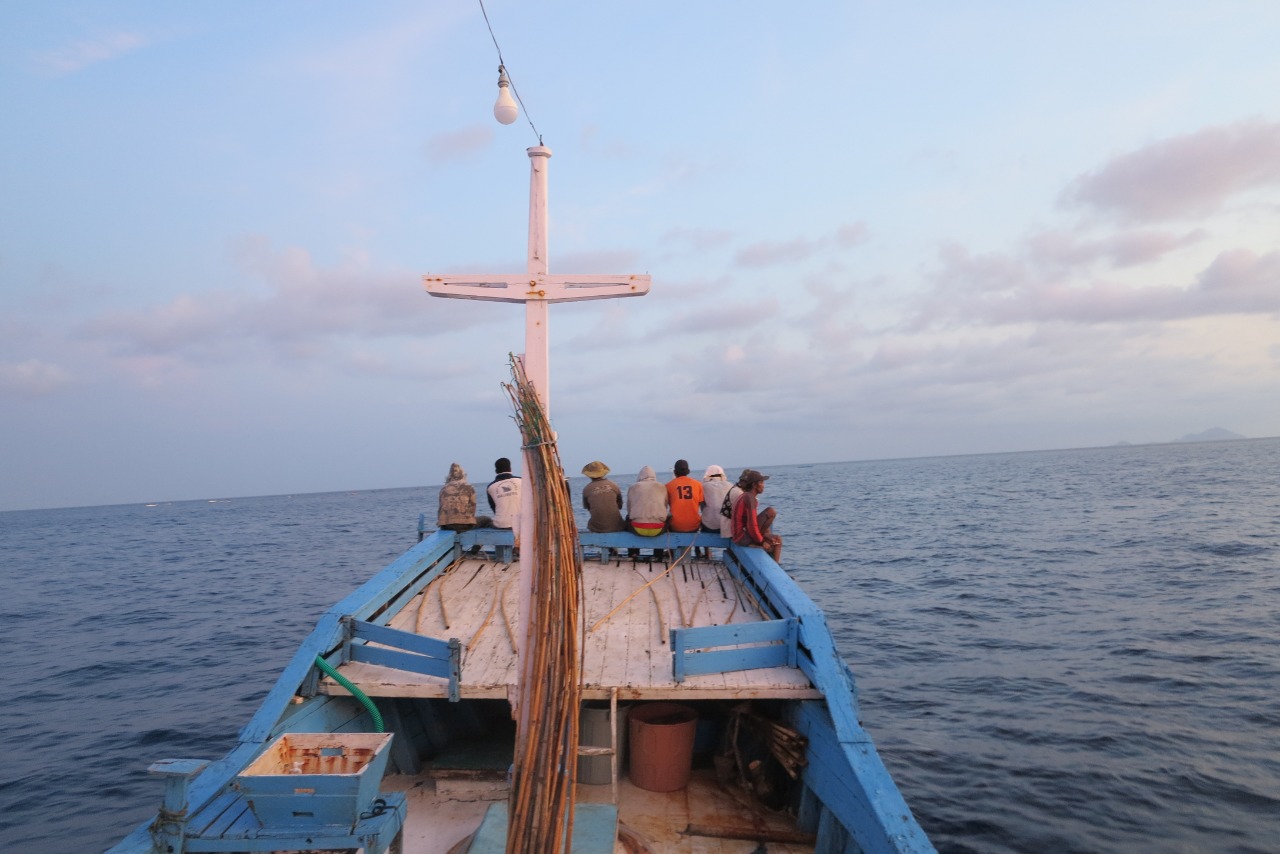 Fishers sitting on deck of vessel