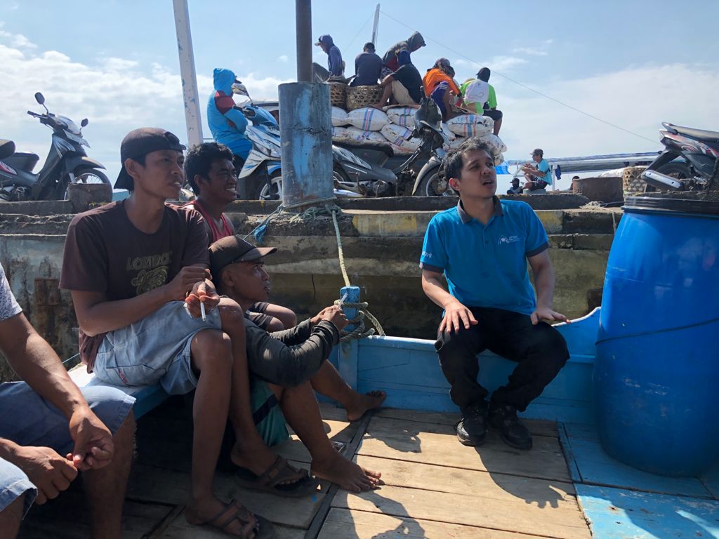 Fishers sitting on deck of vessel