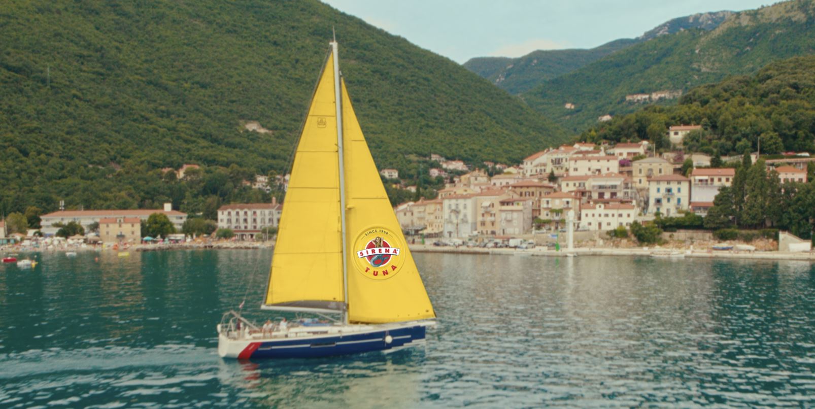 Boat with yellow Sirena sail in the Mediterranean Sea